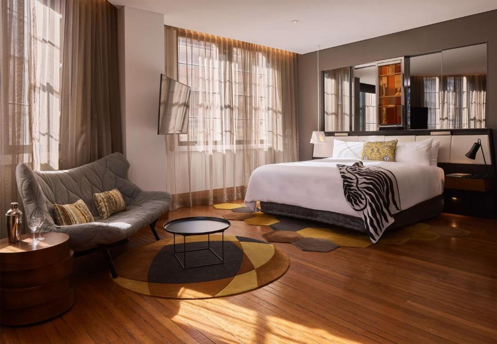 Luxury guest room at QT Sydney featuring a spacious bed, stylish decor, and natural light. Ideal for dog-friendly stays in NSW, offering pet-friendly accommodation for travelers with their furry friends.